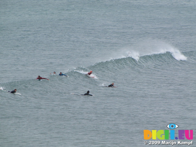 SX06998 Surfers paddling for wave at Bude